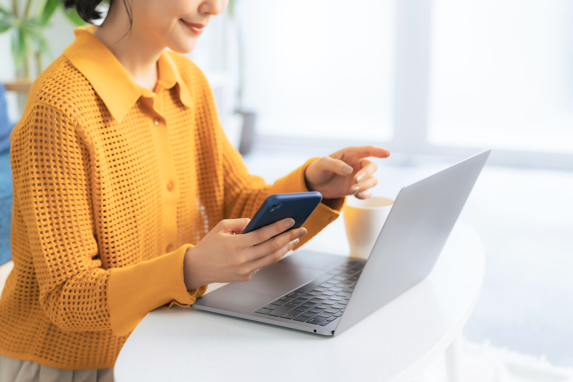 スマートフォンとノートPCを操作する様子